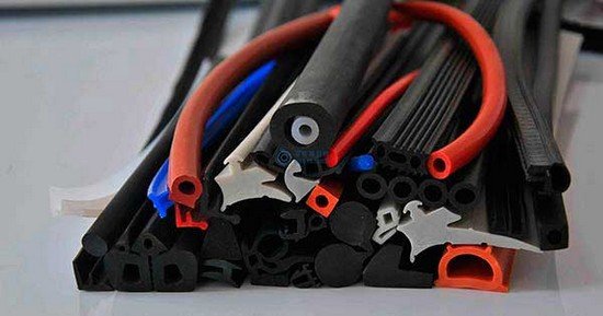 Uma coleção de perfis de extrusão de borracha e silicone coloridos em diversos formatos, tamanhos e cores, incluindo preto, vermelho, azul e branco. Os perfis são empilhados e apresentam uma variedade de designs de seção transversal usados para vedação, isolamento, amortecimento de vibrações e proteção em aplicações industriais e automotivas.
