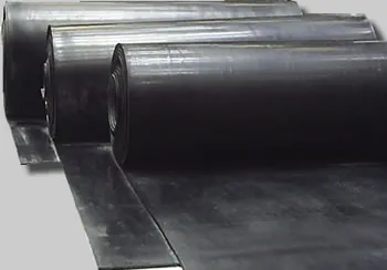A imagem mostra rolos de lençol de borracha preta dispostos em sequência. O material parece resistente e flexível, ideal para uma variedade de aplicações industriais, como selos, juntas e revestimentos.