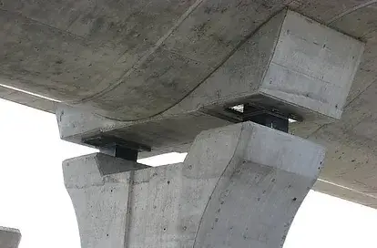A imagem mostra a estrutura de suportes de um viaduto em concreto, destacando os pilares que sustentam a laje superior. Os suportes são projetados para manter a estabilidade e a segurança da construção, permitindo a absorção de forças e oferecendo suporte estrutural. A base dos pilares apresenta um design robusto, indicando a resistência necessária para suportar o peso da via elevada e os veículos que a utilizam.