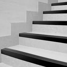 Imagem de uma escada moderna com degraus brancos e detalhes em preto. Os degraus têm acabamento limpo e elegante, criando um contraste visual entre as cores, em um ambiente de design contemporâneo.