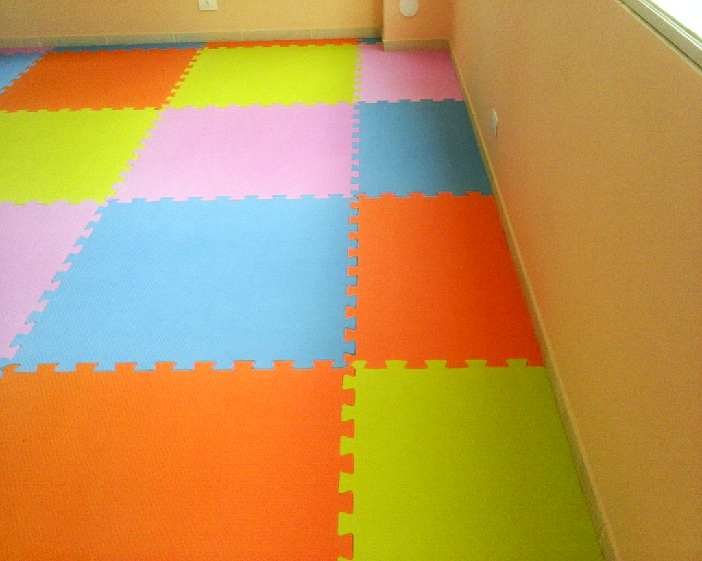 Piso de borracha colorido composto por módulos interligados em diferentes cores, como amarelo, azul, rosa e laranja. Ideal para ambientes infantis, proporcionando segurança e destaque visual ao espaço.