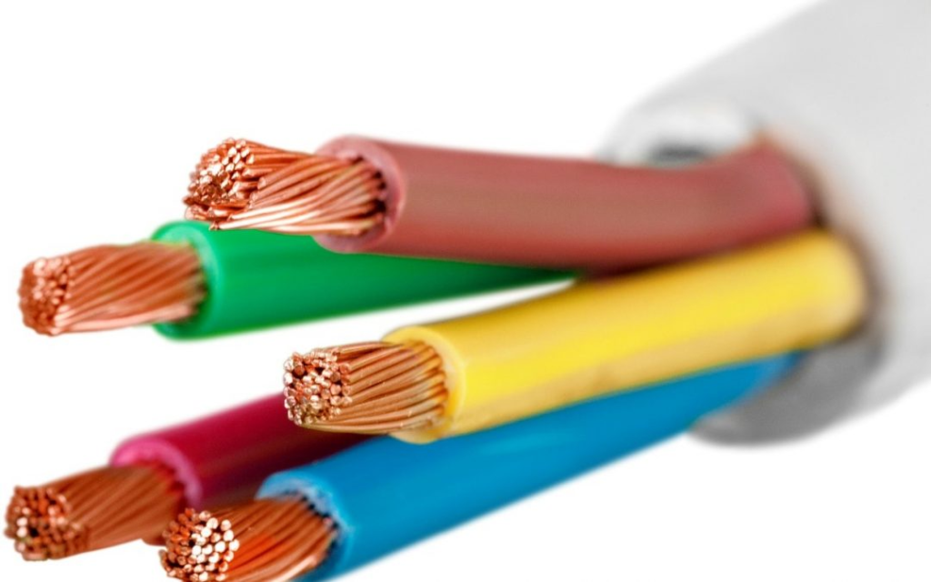 Imagem em close-up de vários fios elétricos com isolamento colorido, incluindo vermelho, verde, amarelo, azul e rosa. Os fios têm fios de cobre expostos nas extremidades, indicando que estão prontos para conexão ou instalação. O fundo é branco, destacando as cores vibrantes e os detalhes finos dos condutores de cobre.