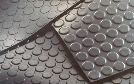tapetes de piso antiderrapantes de borracha cinza, com superfície texturizada de círculos elevados, dispostos sobre uma superfície plana.
