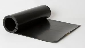 Uma bobina de material de borracha de cor preta, parcialmente desenrolada, mostrando uma porção estendida da fita plana e flexível.