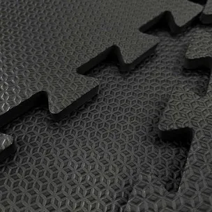 Imagem de várias peças de espuma preta com texturas diferentes, apresentando um padrão de superfície com relevo geométrico, possivelmente usadas para isolamento acústico ou proteção.