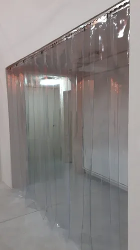 Na foto, vemos uma cortina de PVC transparente MGlasto instalada em um corredor interno. Essa solução é prática para separar setores, controlar poeira e manter a temperatura, sem impedir o fluxo de trabalho.