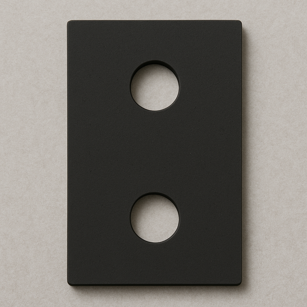 Imagem de uma placa de neoprene preta retangular, com duas cavidades circulares alinhadas verticalmente no centro. Essa peça é utilizada para isolamento, proteção ou absorção de vibrações em aplicações industriais, de manutenção ou equipamentos elétricos, contribuindo para maior durabilidade e segurança das instalações.

