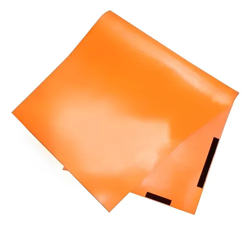 Esta é uma imagem de duas folhas de papel de cor laranja, uma delas ligeiramente dobrada na ponta menor. A superfície do papel apresenta um acabamento brilhante, refletindo a luz, e há detalhes em preto na borda inferior da folha dobrada.