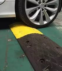 Imagem de Lombada fixada no chão com um carro por cima.