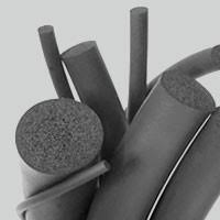 Vários segmentos de borracha cinza-escura em diferentes formatos: cilindros, rolos e anéis, com superfícies lisas e porosas. Alguns elementos aparecem recortados e curvados, sugerindo material flexível usado em vedação ou isolamento. A paleta é monocromática, com sombras suaves que destacam a textura áspera de alguns cortes, transmitindo a ideia de peças de borracha para aplicações industriais.