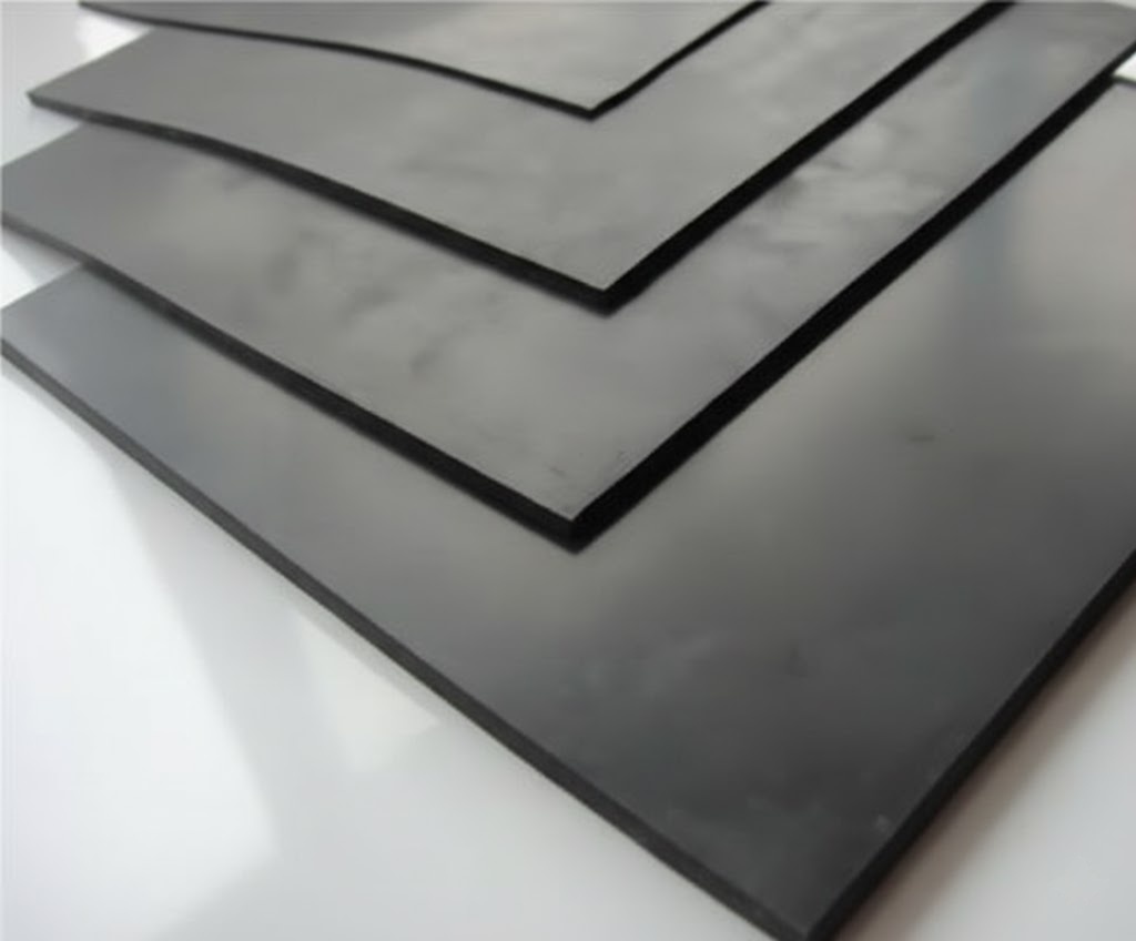 Folhas de borracha preta empilhadas, com superfície lisa e fosca, dispostas em camadas sobre um fundo claro, comumente usadas para fins industriais e profissionais.
