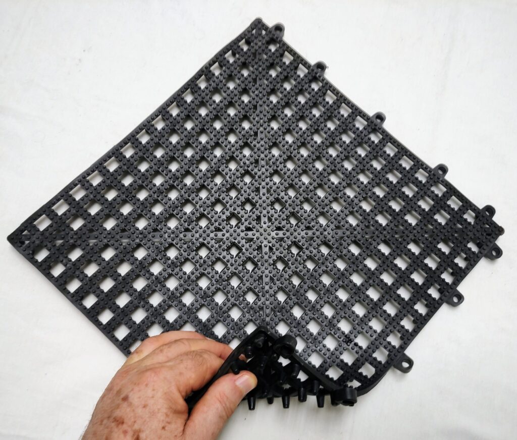 Uma mão segurando uma placa de estrade de pvc vazado