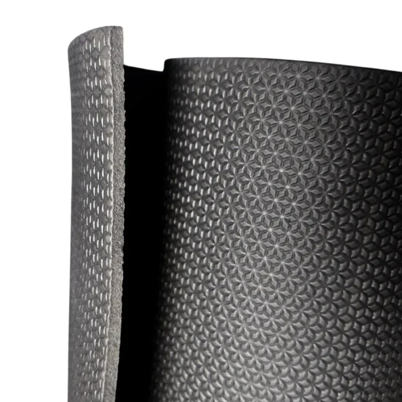 Fábrica ou rolo de revestimento de borracha com textura em padrão de pequenas estrelas ou flores, mostrado em rolo parcialmente desenrolado, utilizado para proteção, isolamento ou acabamento em aplicações industriais.