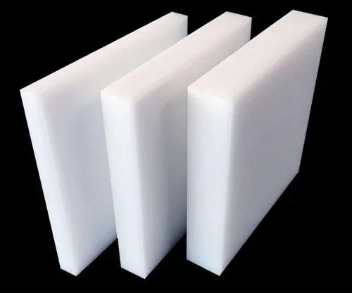 "Três blocos de espuma branca, de formato retangular, alinhados lado a lado contra um fundo preto, evidenciando sua textura lisa e uniforme."