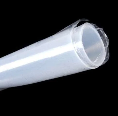 "Um tubo de material transparente, possivelmente plástico ou silicone, cortado diagonalmente na extremidade, exibido contra um fundo preto."