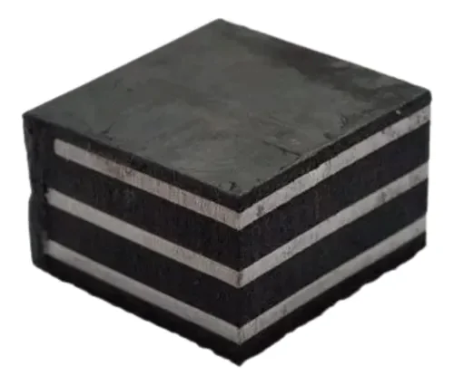 Imagem de uma peça de neoprene fretado, que é uma chapa compacta composta por várias camadas de material de elastômero de neoprene, com uma superfície escura e textura uniforme. O produto é utilizado na construção civil para apoio, isolamento e dispersão de cargas em estruturas pré-moldadas e outros sistemas de engenharia.