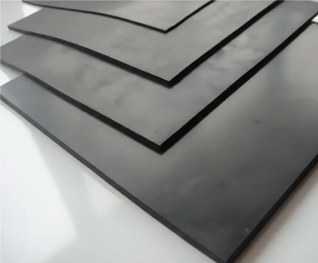 Folhas de borracha preta empilhadas, com superfície lisa e fosca, dispostas em camadas sobre um fundo claro, comumente usadas para fins industriais e profissionais.