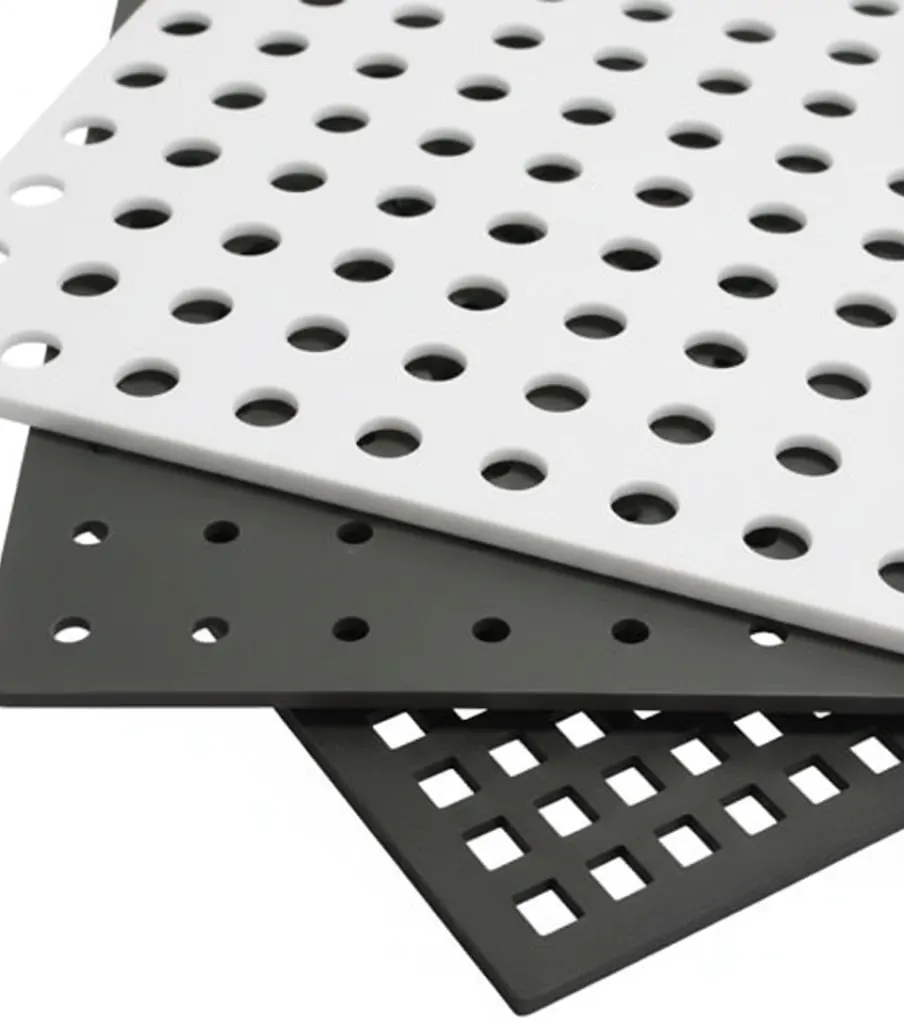 No topo, uma cena realista em uma cozinha industrial onde estrados modulares brancos estão instalados no piso; um deles está levemente levantado para mostrar um canal de escoamento com água e resíduos orgânicos, exemplificando a eficiência na drenagem. Abaixo, três imagens menores exibem variações do produto: modelos vazados com furos quadrados em cores branco, cinza e preto, e modelos com furos circulares, destacando as diferentes opções de design e cores disponíveis para ventilação e segurança do piso.