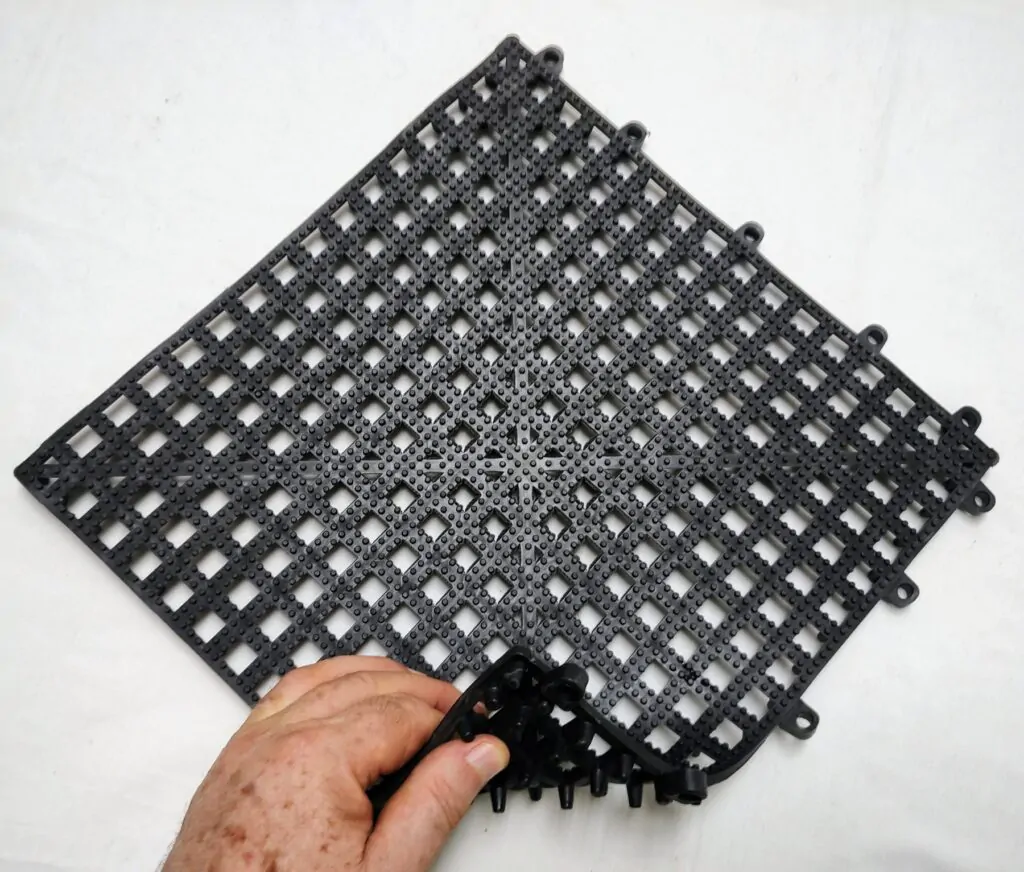 Uma mão segurando uma placa de estrade de pvc vazado 