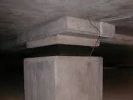 Esta imagem ilustra a aplicação prática dos componentes mostrados anteriormente. Ela exibe um aparelho de apoio de elastômero instalado em uma estrutura real, servindo como interface entre um pilar e uma viga ou laje.
